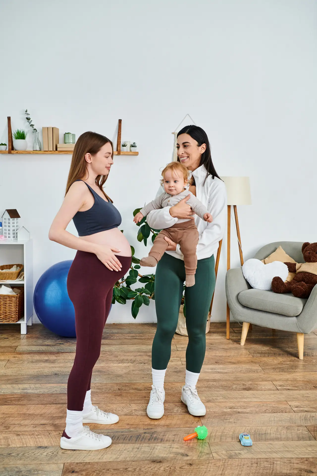a young beautiful mother is tenderly holding her baby while standing next to her coach at a parents course, receiving guidance and support.
