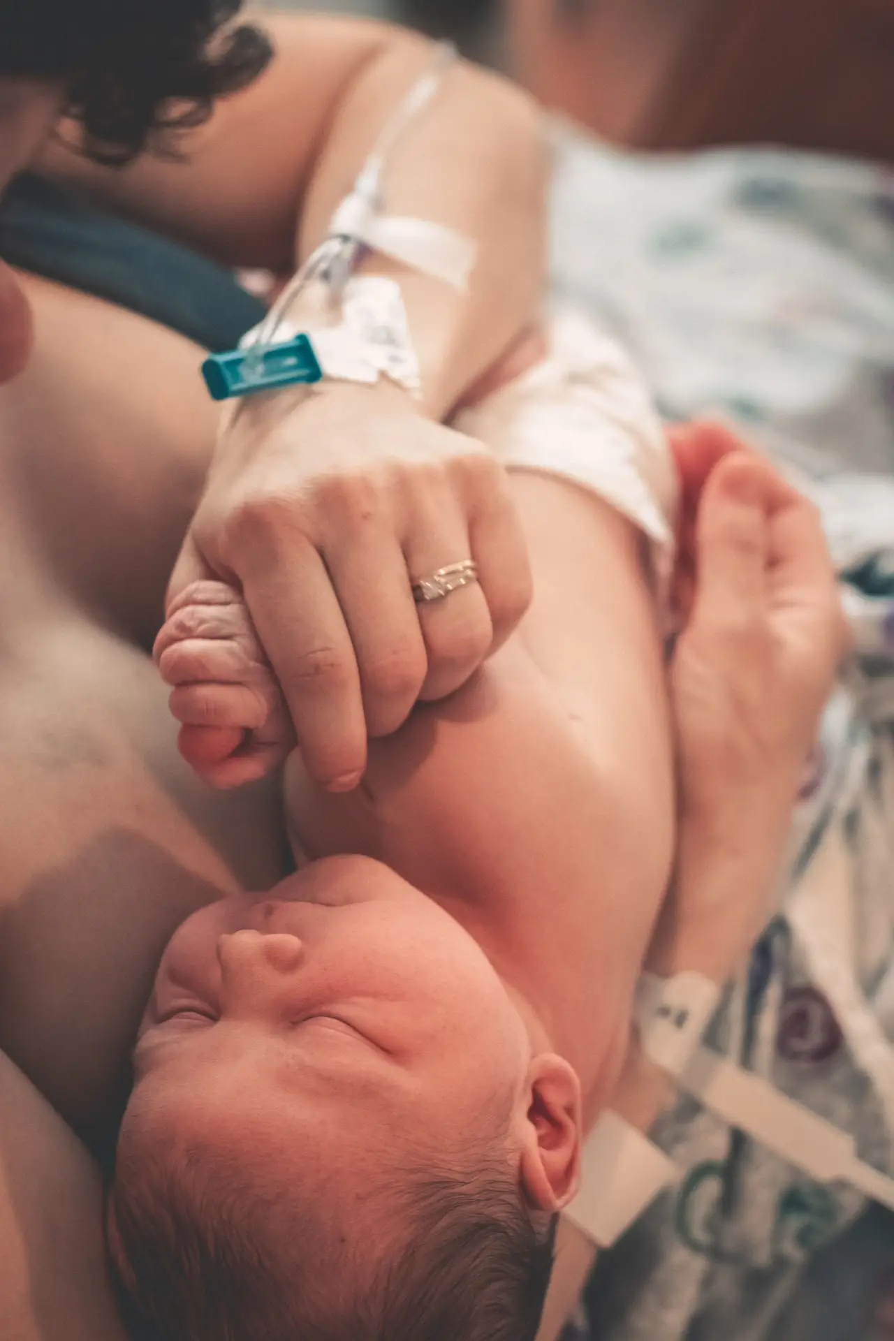 Close-up of a newborn baby holding its mother's hand, symbolizing love and connection.